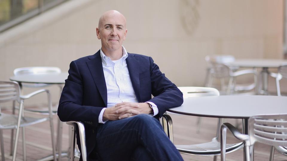 Brent Smith sitting at metal tables outdoors